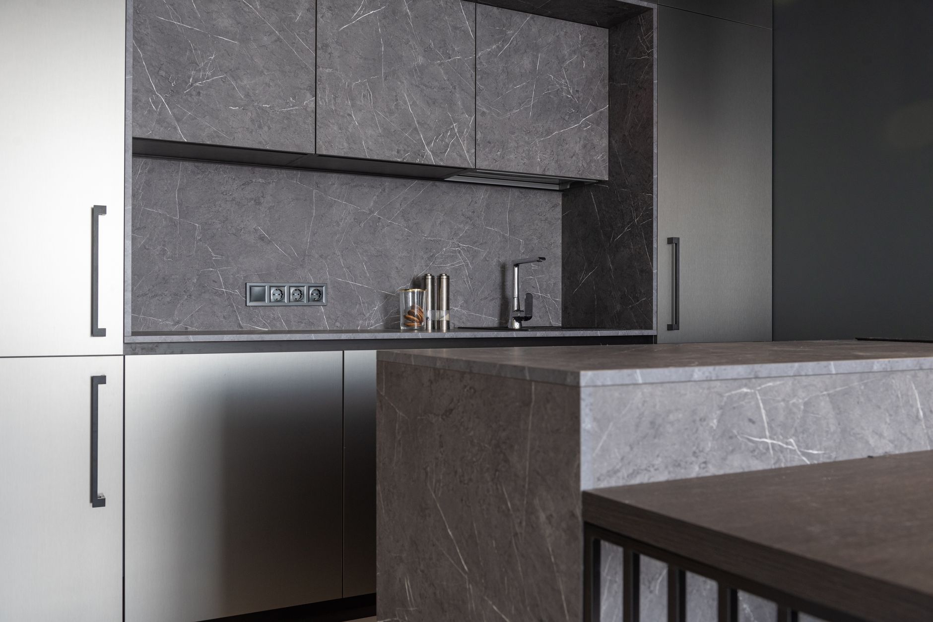 Interior of contemporary kitchen with minimalist gray furniture and counter in residential apartment in Riverside, CA